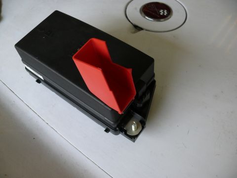 1976 Chevrolet Corvette - A black fuse box with a red cover is shown, likely a part from a Corvette.