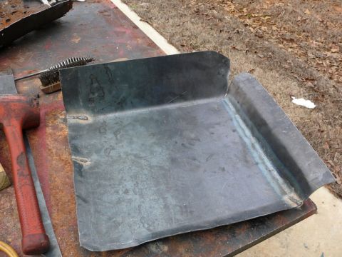 1976 Chevrolet Corvette - A fabricated metal part, likely for automotive repair, sits on a workbench with tools.