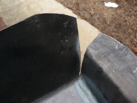 1976 Chevrolet Corvette - Close-up of two curved metal components, likely automotive parts, showing their edges and construction.