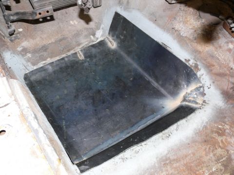 1976 Chevrolet Corvette - A close-up view of a car's interior floor pan, a newly welded metal section and visible pedals.