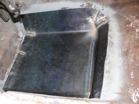1976 Chevrolet Corvette - The interior floor pan of a 1976 Chevrolet Corvette shows a newly welded metal patch, indicating repair work.
