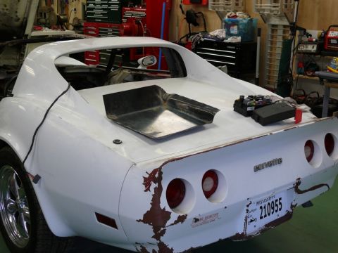 1976 Chevrolet Corvette - This 1976 Chevrolet Corvette is undergoing repairs in a garage, showing its rear end with a custom hood scoop.