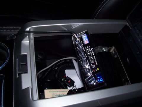 1978 Ford F-150 - A Cobra CB radio is visible inside the center console of a vehicle, alongside car keys and other items.