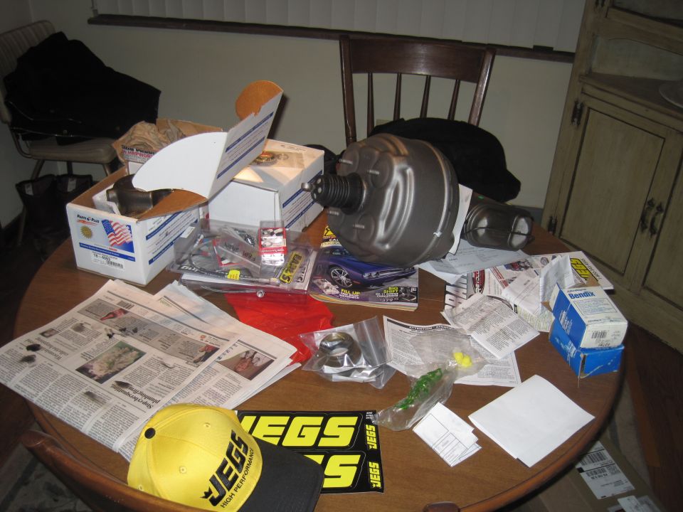 Brake booster and assorted parts on a table with JEGS branding