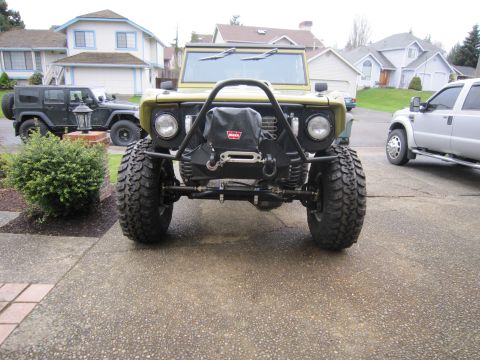 1996 Ford Bronco - Modified 1978 Ford Bronco features a winch and brush guard, parked in a driveway with other vehicles.