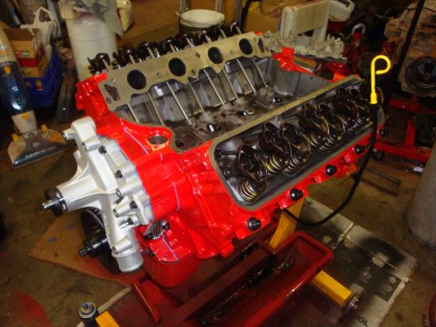 1989 Ford Bronco - A red engine block with a silver water pump and valve covers is shown, possibly undergoing a rebuild.