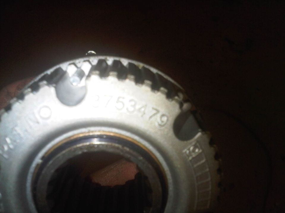 Close-up of a metal part with teeth and numbers 2753479 stamped on it