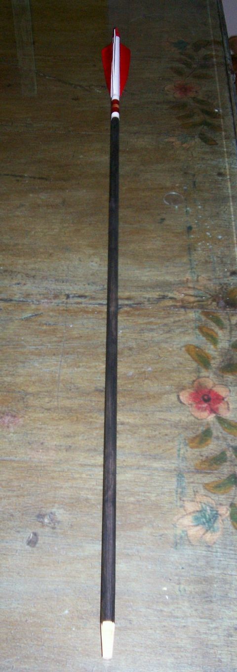 1993 Ford Bronco - This is a close-up of an arrow with red and white fletching, resting on a patterned surface.