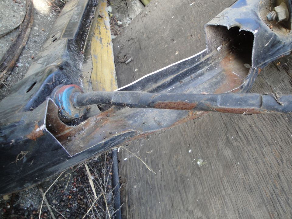 Close-up of a rusty subframe part with a blue bushing