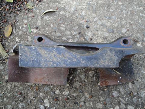 1995 Ford Taurus - A metal subframe part, likely from a vehicle, is shown resting on rusty metal fragments.