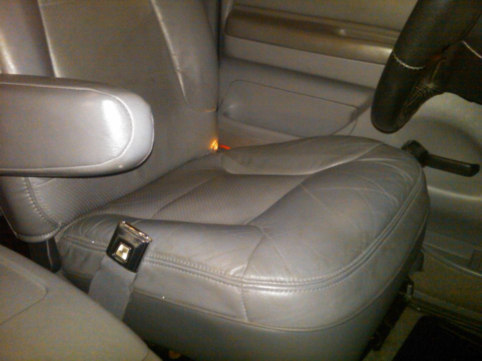 Gray leather bucket seat interior with armrest and seatbelt