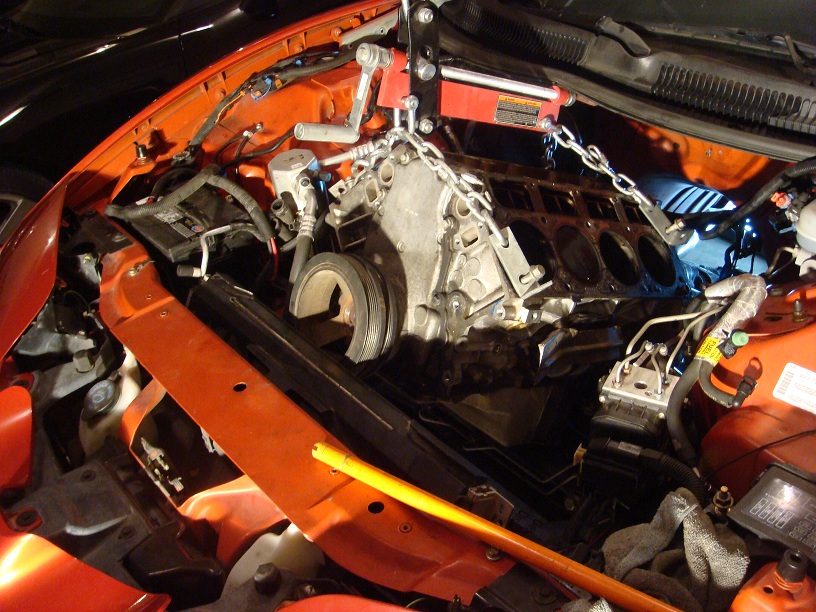 Orange engine bay with engine hoist removing V8 engine