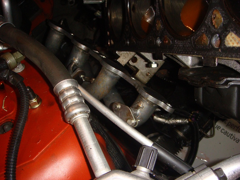 Close-up of an engine's exhaust manifold and associated plumbing