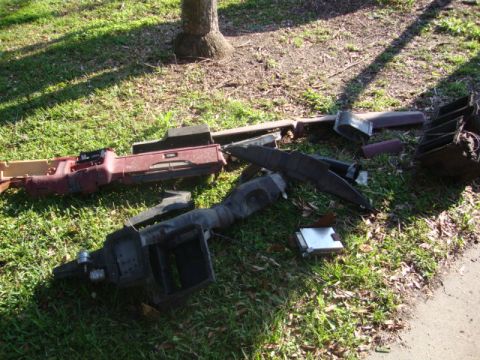 1986 Ford Bronco - Various interior dashboard parts are scattered on the grass, suggesting a disassembly or repair process.