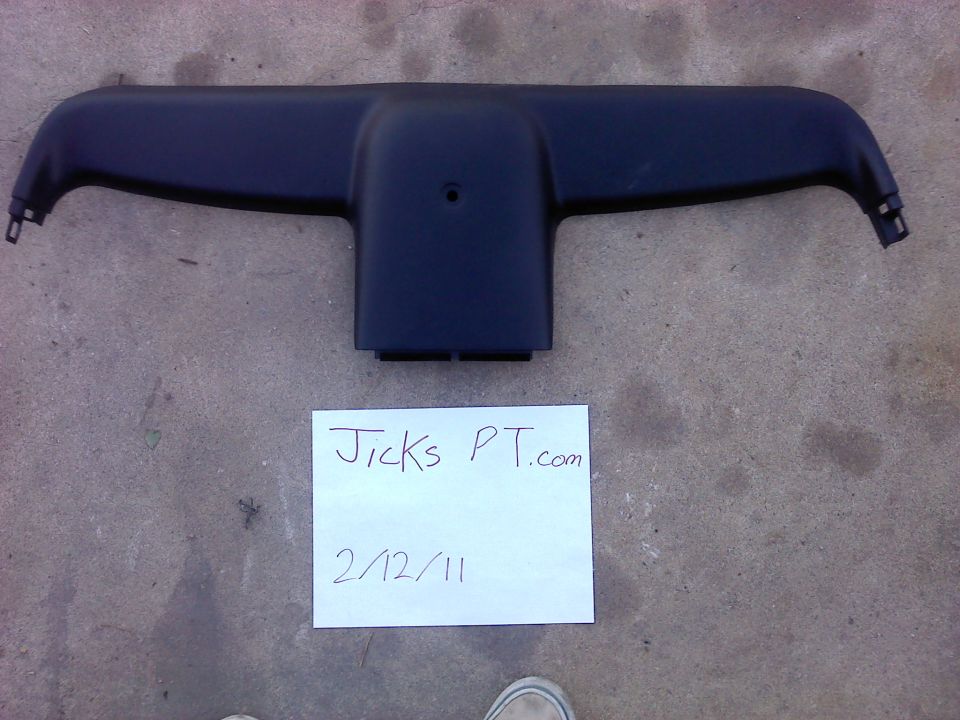Black plastic automotive interior trim piece with mounting tabs on the sides