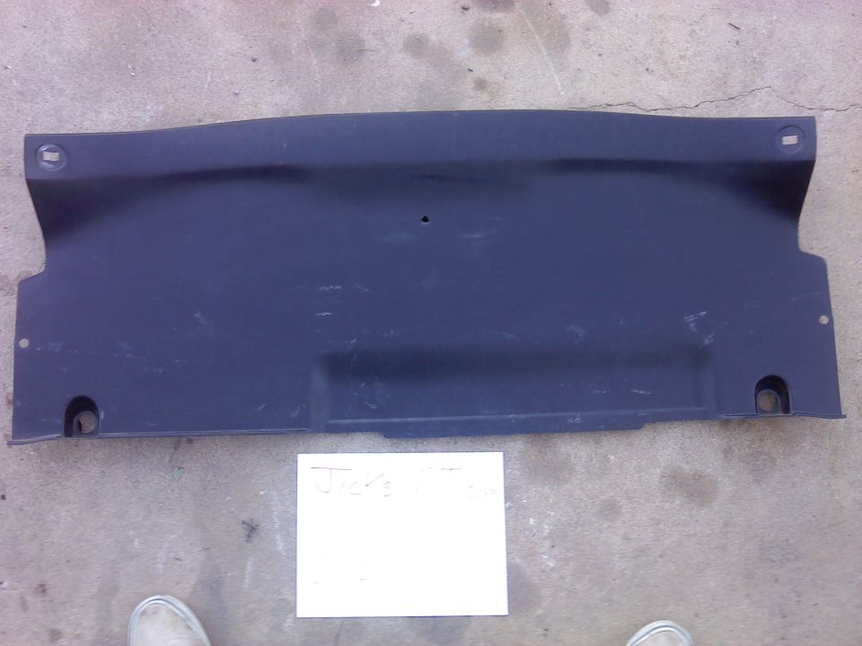 Dark plastic automotive underbody panel with mounting holes