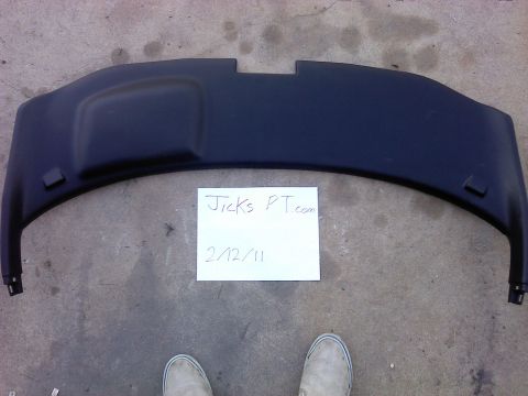 1995 Ford Probe - A black plastic automotive part is shown with a handwritten note and two pairs of shoes.