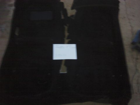 1995 Ford Probe - Black car floor mats are laid out flat on a concrete surface.