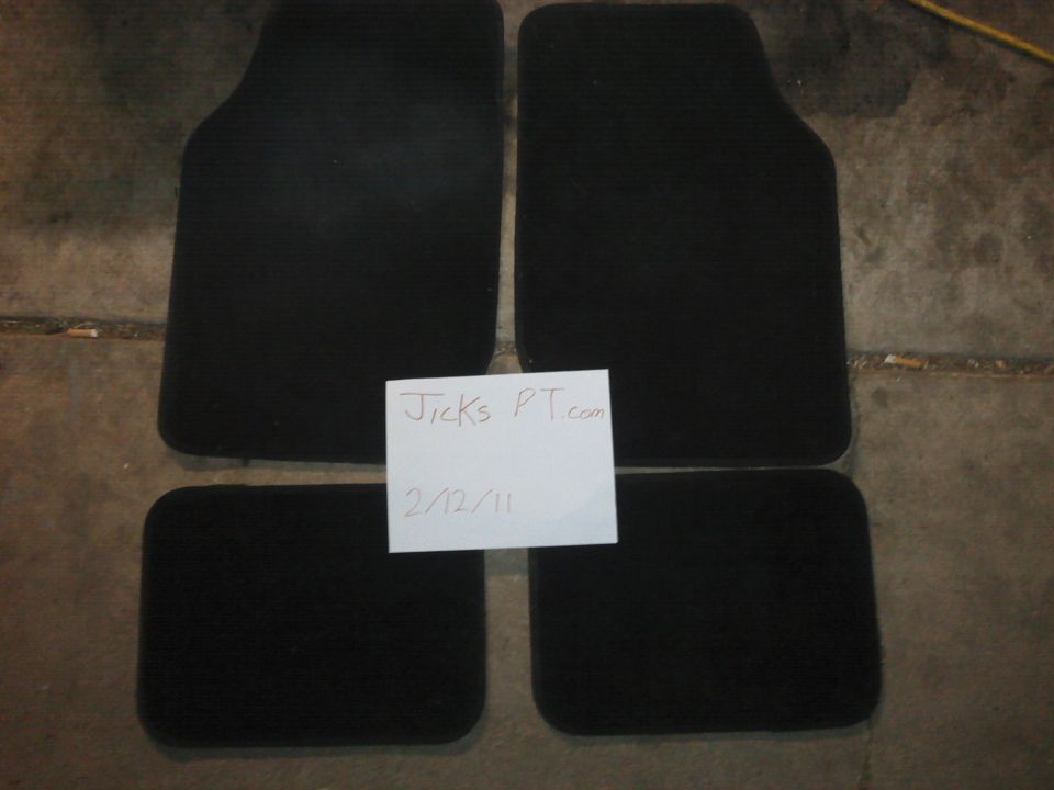 Four black car floor mats on a concrete floor, with a note that says "Jicks PT.com 2/12/11"