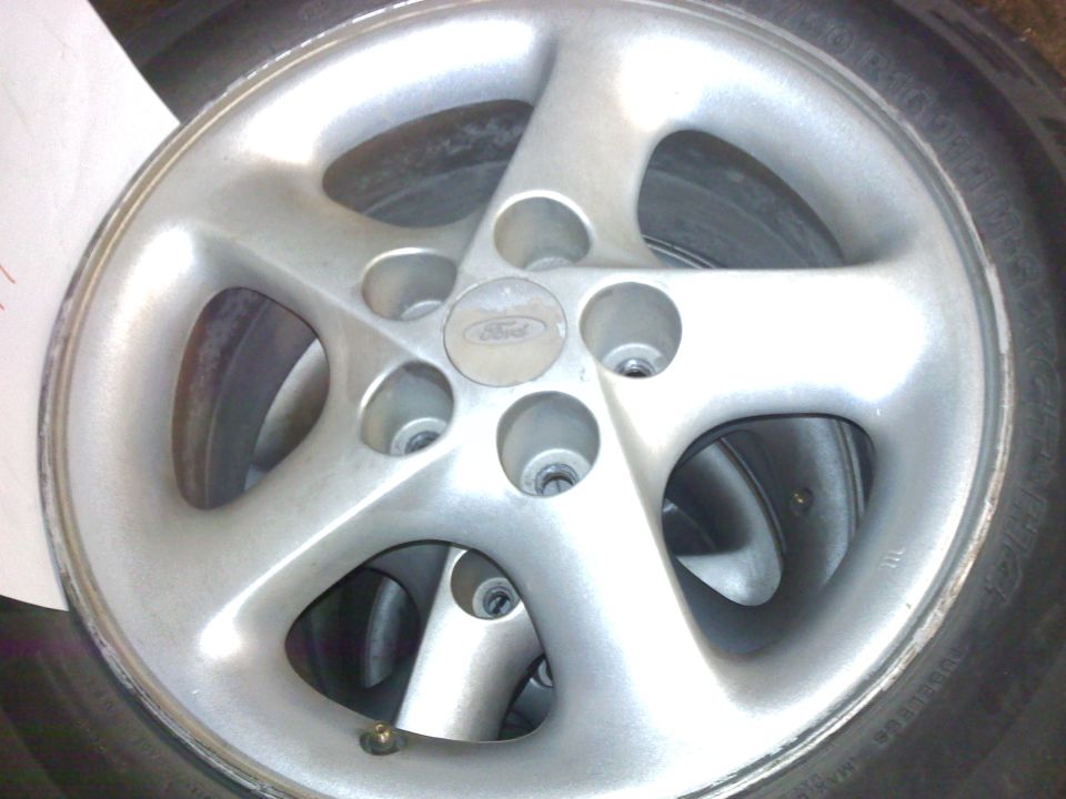 Silver five-spoke Ford wheel with center cap