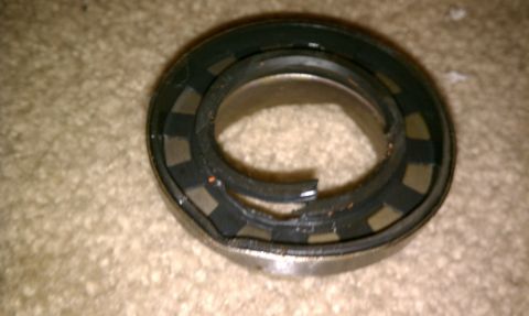 1990 Ford Bronco - A close-up view of a damaged bearing seal, showing its internal structure and signs of wear.