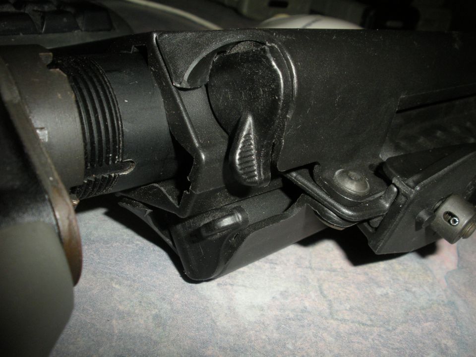 Close-up of black firearm receiver with selector switch and textured grip