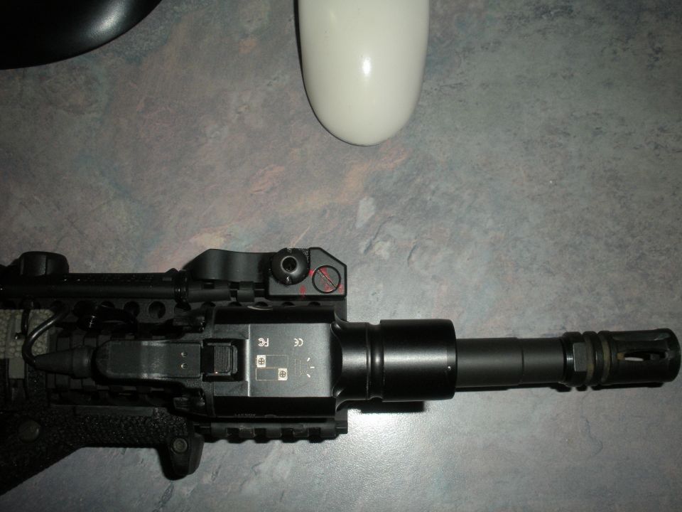 Close-up of firearm barrel with muzzle brake and tactical light