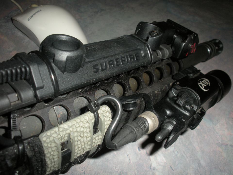 Close-up of Surefire weapon light and rail-mounted accessories on a rifle