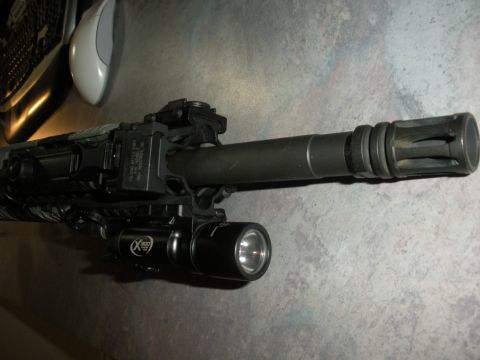 1996 Ford Bronco - Close-up of a tactical flashlight and laser sight mounted on a rifle barrel.