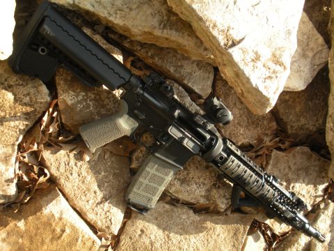 1996 Ford Bronco - An assault rifle is shown resting on a rocky surface, with a watermark for SuperMotors.net visible.