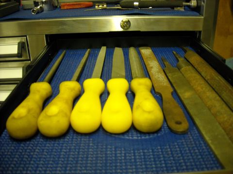1979 Ford F-150 - A collection of files and rasps with bright yellow handles are neatly organized in a mechanic's toolbox drawer.