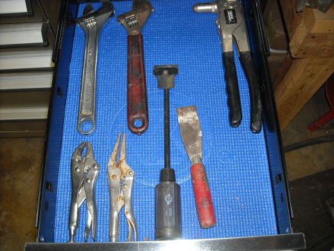 1979 Ford F-150 - A collection of mechanic's tools including wrenches, pliers, a rivet gun, and chisels.