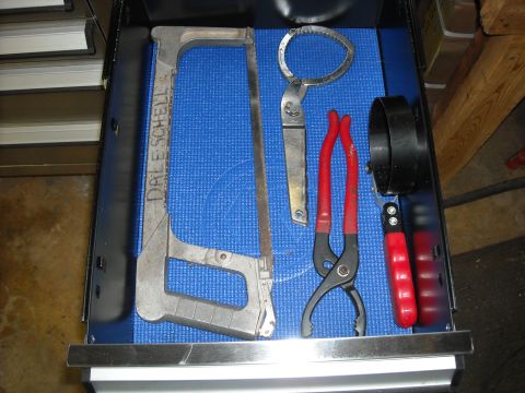 1979 Ford F-150 - A collection of automotive tools, including a hacksaw and various wrenches, are neatly organized in a toolbox drawer.