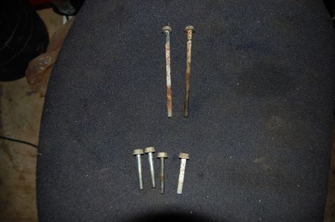 2006 Honda RANCHER - A collection of assorted bolts, some showing signs of rust, are laid out on a textured dark surface.