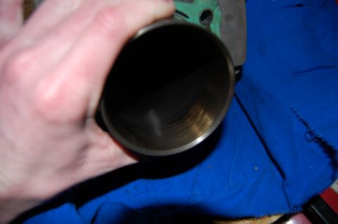 2006 Honda RANCHER - A hand holds a cylinder bore, revealing the cross-hatch pattern from the honing process.
