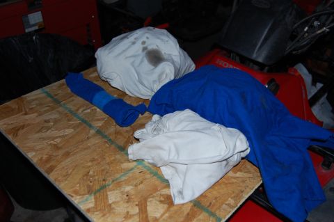2006 Honda RANCHER - A pile of rags and engine components are laid out on a wooden surface, with a red Honda ATV partially visible.