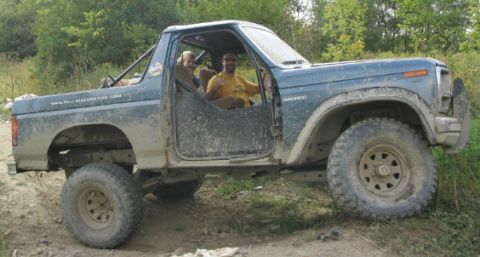 1986 Ford Bronco - This lifted, blue Ford Bronco from the 1980s features a distinctive side profile and aftermarket wheels.
