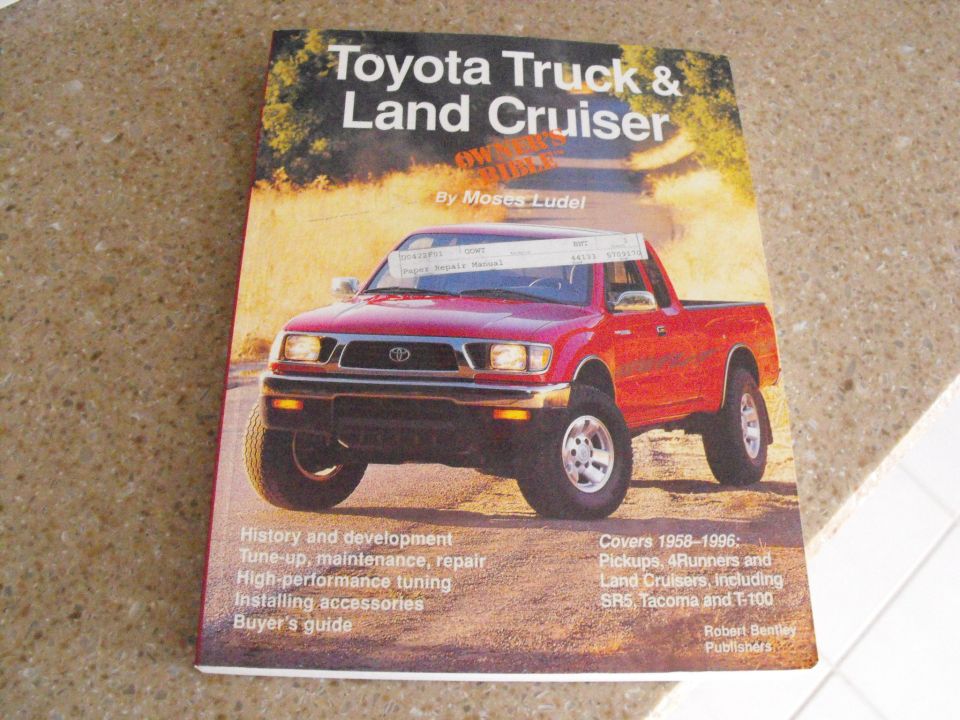 Book cover titled "Toyota Truck & Land Cruiser" with a red Toyota pickup truck on the front