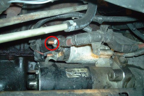 1993 Ford Taurus - Remove the red ground wire (circled) and the solenoid relay wire (thin red) from the starter.