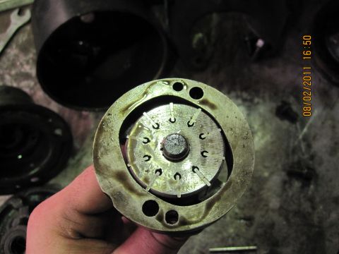 1973 Ford Ranchero - Close-up of a metal automotive part with pins, held by a hand.