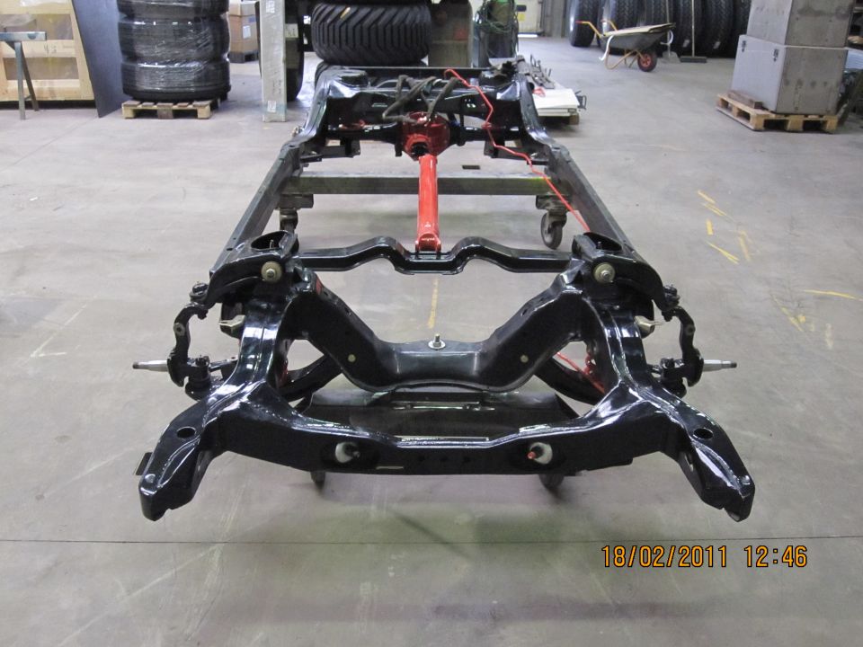 vehicle frame on casters, front suspension visible, red support in middle