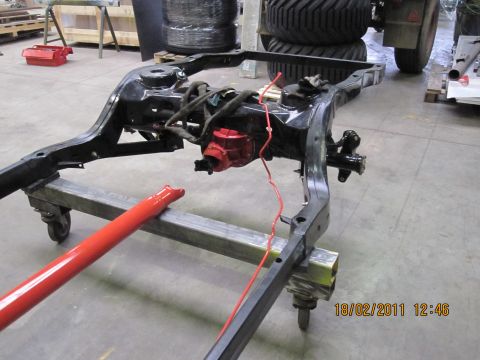 1973 Ford Ranchero - Vehicle frame assembly on a rolling stand, with red painted driveshaft piece. Date stamp 18/02/2011.
