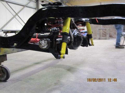 1973 Ford Ranchero - The rear suspension system of a vehicle is shown, bright yellow shock absorbers and red coil springs.