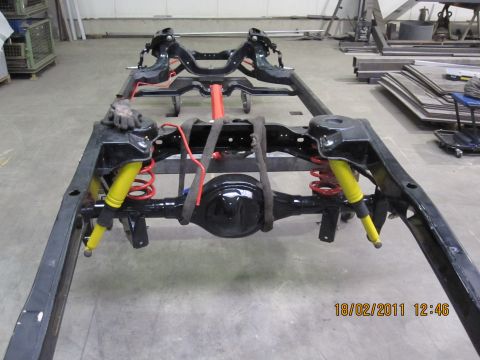 1973 Ford Ranchero - The chassis of a vehicle is shown in a workshop setting, with visible suspension components.