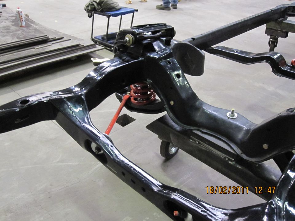 Black vehicle frame with red springs and suspension parts