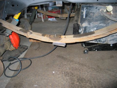 1984 Ford Bronco - Underside view of a vehicle's suspension system, focusing on the leaf spring and associated components.