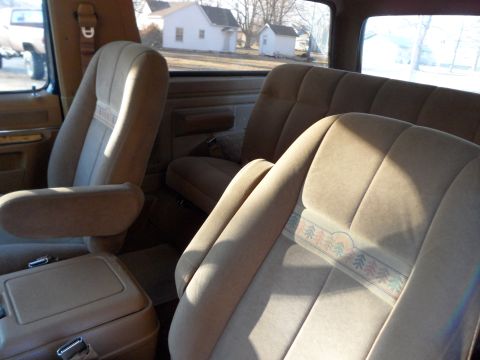 1989 Ford Bronco - Tan fabric seats with a decorative stripe are visible inside the vehicle.