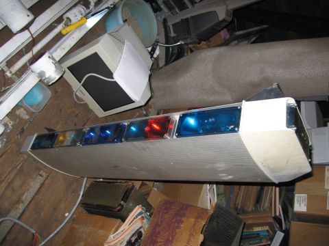 2001 Ford Crown Victoria - A light bar with multiple blue and red lights is visible in a cluttered room.