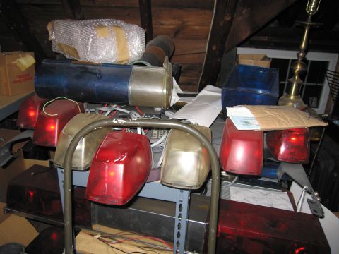 2001 Ford Crown Victoria - Various emergency lights and equipment are stored in a cluttered attic space.