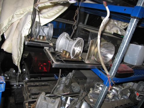 2001 Ford Crown Victoria - Automotive headlights and parts are organized on shelves, suggesting a collection or repair area.